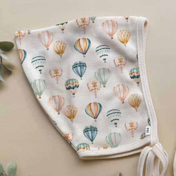 A bonnet with a balloon pattern on a neutral background