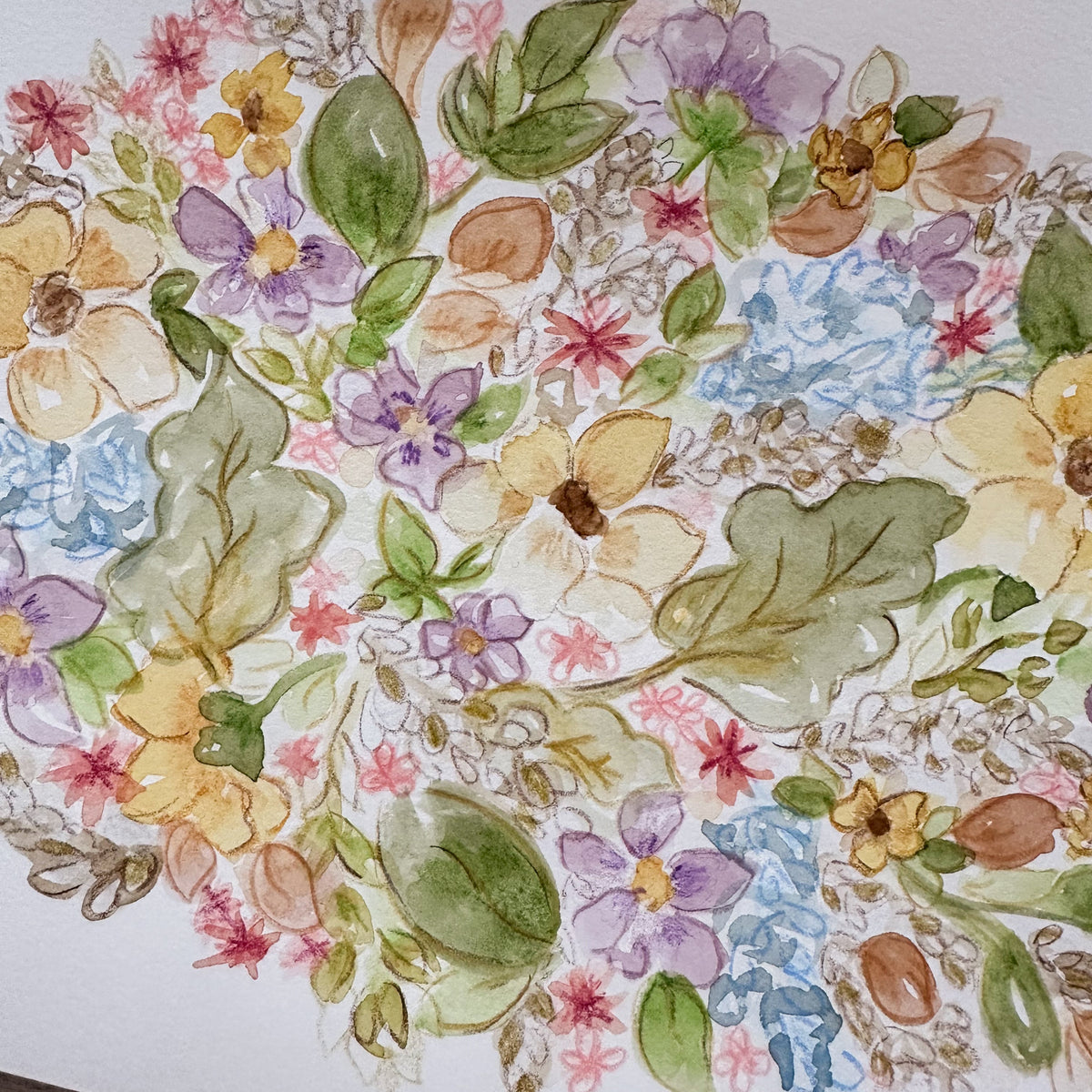 A watercolor floral art print featuring a dense arrangement of pastel flowers and leaves in yellow, purple, blue, pink, green, and brown tones on a white sheet of paper.